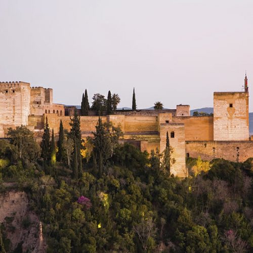 The Alhambra, with illuminated Alcazaba section, at dusk from Granada's AlbaicÌn district.