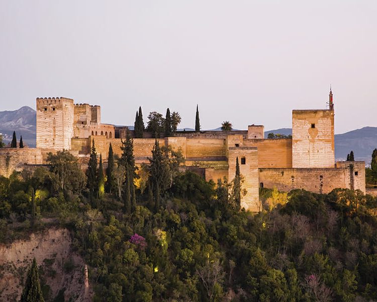The Alhambra, with illuminated Alcazaba section, at dusk from Granada's AlbaicÌn district.